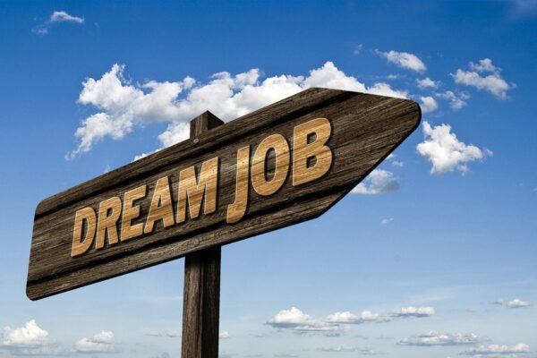 Wooden sign against blue sky that reads "dream job"